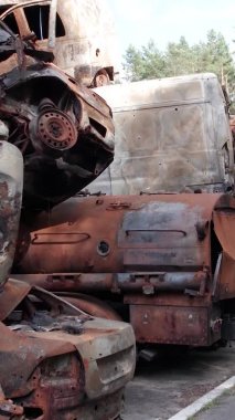 Bu stok dikey video Irpin, Bucha bölgesinde bir kurşun ve yanmış araba dökümü gösteriyor.