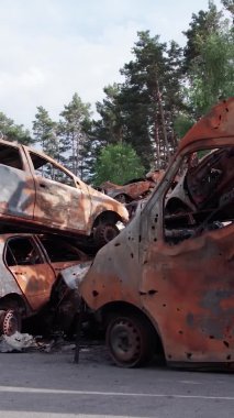 Bu stok dikey video Irpin, Bucha bölgesinde bir kurşun ve yanmış araba dökümü gösteriyor.