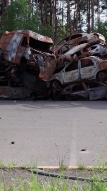 Bu stok dikey video Irpin, Bucha bölgesinde bir kurşun ve yanmış araba dökümü gösteriyor.