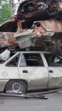 Bu stok dikey video Irpin, Bucha bölgesinde bir kurşun ve yanmış araba dökümü gösteriyor.