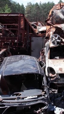 Bu stok dikey video Irpin, Bucha bölgesinde bir kurşun ve yanmış araba dökümü gösteriyor.