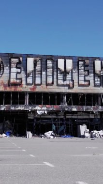 This stock vertical video shows a destroyed by war building of a shopping center in Bucha, Ukraine, slow motion
