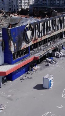 This stock vertical video shows a destroyed by war building of a shopping center in Bucha, Ukraine, slow motion