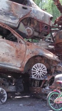 Bu stok dikey video Irpin, Bucha bölgesinde bir kurşun ve yanmış araba dökümü gösteriyor.