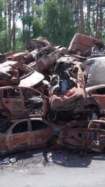 Bu stok dikey video Irpin, Bucha bölgesinde bir kurşun ve yanmış araba dökümü gösteriyor.