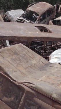 Bu stok dikey video Irpin, Bucha bölgesinde bir kurşun ve yanmış araba dökümü gösteriyor.