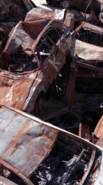 Bu stok dikey video Irpin, Bucha bölgesinde bir kurşun ve yanmış araba dökümü gösteriyor.