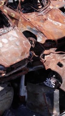 Bu stok dikey video Irpin, Bucha bölgesinde bir kurşun ve yanmış araba dökümü gösteriyor.