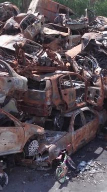 Bu stok dikey video Irpin, Bucha bölgesinde bir kurşun ve yanmış araba dökümü gösteriyor.