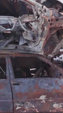 Bu stok dikey video Irpin, Bucha bölgesinde bir kurşun ve yanmış araba dökümü gösteriyor.