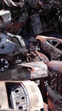 Bu stok dikey video Irpin, Bucha bölgesinde bir kurşun ve yanmış araba dökümü gösteriyor.