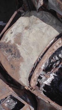 Bu stok dikey video Irpin, Bucha bölgesinde gri, düz, renksiz, yanmış arabaları gösteriyor.