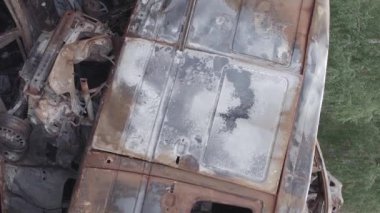 Bu stok dikey video Irpin, Bucha bölgesinde gri, düz, renksiz, yanmış arabaları gösteriyor.