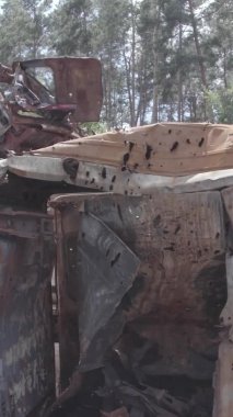 Bu stok dikey video Irpin, Bucha bölgesinde gri, düz, renksiz, yanmış arabaları gösteriyor.