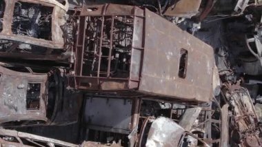 Bu stok dikey video Irpin, Bucha bölgesinde gri, düz, renksiz, yanmış arabaları gösteriyor.