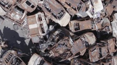 Bu stok dikey video Irpin, Bucha bölgesinde gri, düz, renksiz, yanmış arabaları gösteriyor.