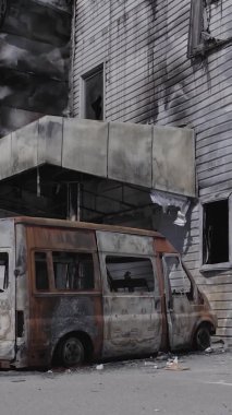 Bu dikey video, Bucha, Ukrayna 'da bir alışveriş merkezinin savaş tarafından tahrip edildiğini gösteriyor. Ağır çekim, gri, renksiz, düz.