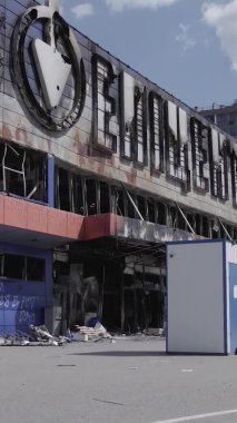 Bu dikey video, Bucha, Ukrayna 'da bir alışveriş merkezinin savaş tarafından tahrip edildiğini gösteriyor. Ağır çekim, gri, renksiz, düz.
