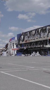 Bu dikey video, Bucha, Ukrayna 'da bir alışveriş merkezinin savaş tarafından tahrip edildiğini gösteriyor. Ağır çekim, gri, renksiz, düz.