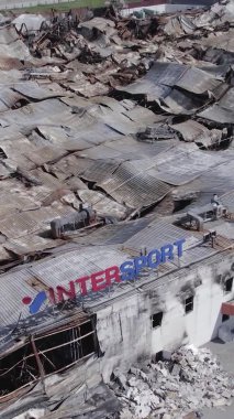 Bu dikey video, Bucha, Ukrayna 'da bir alışveriş merkezinin savaş tarafından tahrip edildiğini gösteriyor. Ağır çekim, gri, renksiz, düz.