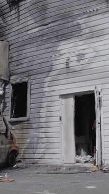 Bu dikey video, Bucha, Ukrayna 'da bir alışveriş merkezinin savaş tarafından tahrip edildiğini gösteriyor. Ağır çekim, gri, renksiz, düz.