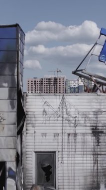 Bu dikey video, Bucha, Ukrayna 'da bir alışveriş merkezinin savaş tarafından tahrip edildiğini gösteriyor. Ağır çekim, gri, renksiz, düz.