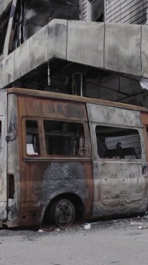 Bu dikey video, Bucha, Ukrayna 'da bir alışveriş merkezinin savaş tarafından tahrip edildiğini gösteriyor. Ağır çekim, gri, renksiz, düz.