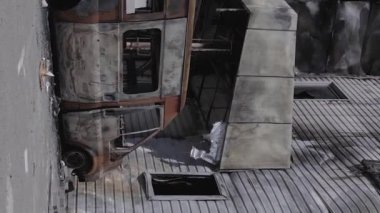 Bu dikey video, Bucha, Ukrayna 'da bir alışveriş merkezinin savaş tarafından tahrip edildiğini gösteriyor. Ağır çekim, gri, renksiz, düz.