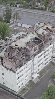 Bu borsa dikey videosu Stoyanka, Bucha bölgesinde, Ukrayna 'da, gri, renksiz, düz bir bina gösteriyor.