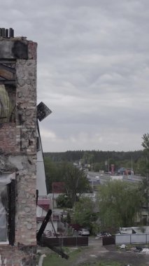 Bu borsa dikey videosu Stoyanka, Bucha bölgesinde, Ukrayna 'da, gri, renksiz, düz bir bina gösteriyor.