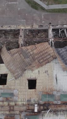 Bu borsa dikey videosu Stoyanka, Bucha bölgesinde, Ukrayna 'da, gri, renksiz, düz bir bina gösteriyor.