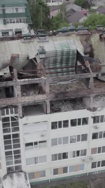 Bu borsa dikey videosu Stoyanka, Bucha bölgesinde, Ukrayna 'da, gri, renksiz, düz bir bina gösteriyor.