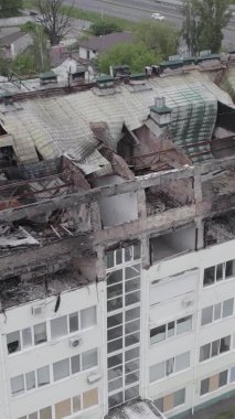 Bu borsa dikey videosu Stoyanka, Bucha bölgesinde, Ukrayna 'da, gri, renksiz, düz bir bina gösteriyor.