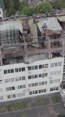 Bu borsa dikey videosu Stoyanka, Bucha bölgesinde, Ukrayna 'da, gri, renksiz, düz bir bina gösteriyor.