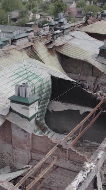 Bu borsa dikey videosu Stoyanka, Bucha bölgesinde, Ukrayna 'da, gri, renksiz, düz bir bina gösteriyor.