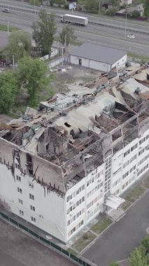 Bu borsa dikey videosu Stoyanka, Bucha bölgesinde, Ukrayna 'da, gri, renksiz, düz bir bina gösteriyor.