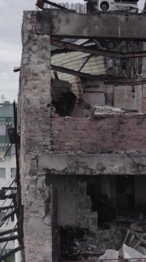 Bu borsa dikey videosu Stoyanka, Bucha bölgesinde, Ukrayna 'da, gri, renksiz, düz bir bina gösteriyor.