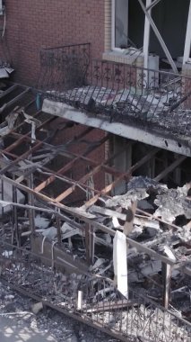 Bu dikey video Ukrayna 'daki savaş sırasında Makariv şehrinde yıkılmış bir binayı gösteriyor. Gri, renksiz, düz.