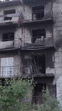 Bu dikey video Ukrayna 'daki savaş sırasında Makariv şehrinde yıkılmış bir binayı gösteriyor. Gri, renksiz, düz.