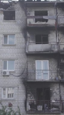 Bu dikey video Ukrayna 'daki savaş sırasında Makariv şehrinde yıkılmış bir binayı gösteriyor. Gri, renksiz, düz.