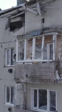 This stock vertical video shows a destroyed building in the city of Makariv during the war in Ukraine, grey, no color, flat