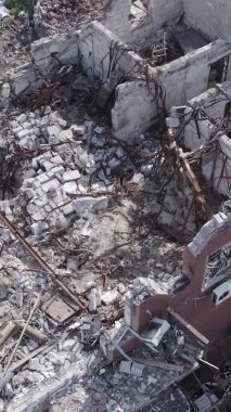 Bu dikey video Ukrayna 'daki savaş sırasında Makariv şehrinde yıkılmış bir binayı gösteriyor. Gri, renksiz, düz.