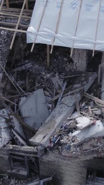Bu dikey video Ukrayna 'daki savaş sırasında Makariv şehrinde yıkılmış bir binayı gösteriyor. Gri, renksiz, düz.