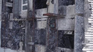Bu dikey video Ukrayna 'daki savaş sırasında Makariv şehrinde yıkılmış bir binayı gösteriyor. Gri, renksiz, düz.