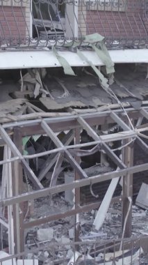 This stock vertical video shows a destroyed building in the city of Makariv during the war in Ukraine, grey, no color, flat