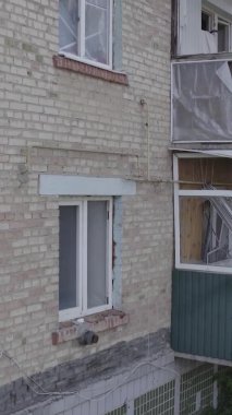 Bu dikey video Ukrayna 'daki savaş sırasında Makariv şehrinde yıkılmış bir binayı gösteriyor. Gri, renksiz, düz.