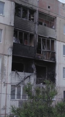 This stock vertical video shows a destroyed building in the city of Makariv during the war in Ukraine, grey, no color, flat