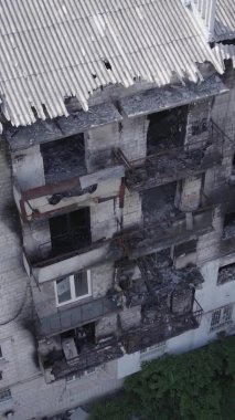 Bu dikey video Ukrayna 'daki savaş sırasında Makariv şehrinde yıkılmış bir binayı gösteriyor. Gri, renksiz, düz.