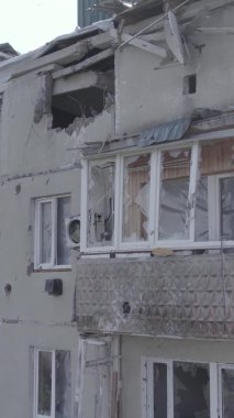 This stock vertical video shows a destroyed building in the city of Makariv during the war in Ukraine, grey, no color, flat