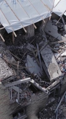 Bu dikey video Ukrayna 'daki savaş sırasında Makariv şehrinde yıkılmış bir binayı gösteriyor. Gri, renksiz, düz.